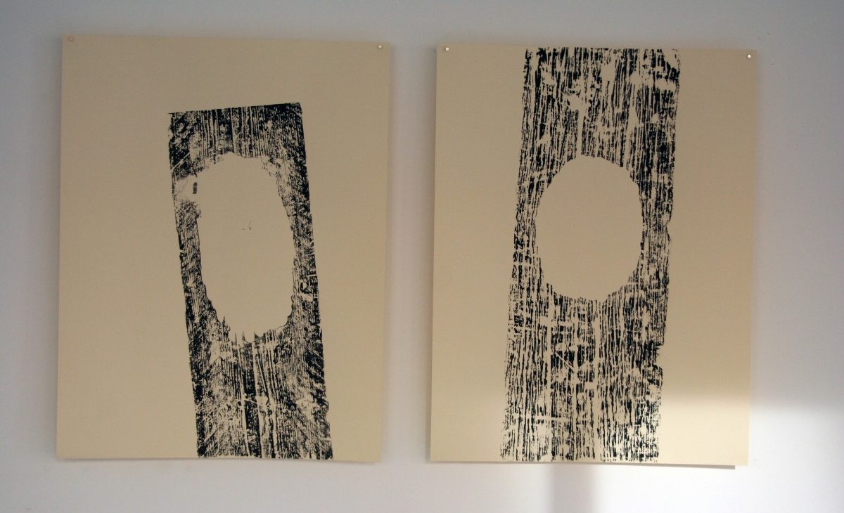 Two woodblock prints in black ink on cream paper; Woodgrain stripes with an oval hole showing cream paper