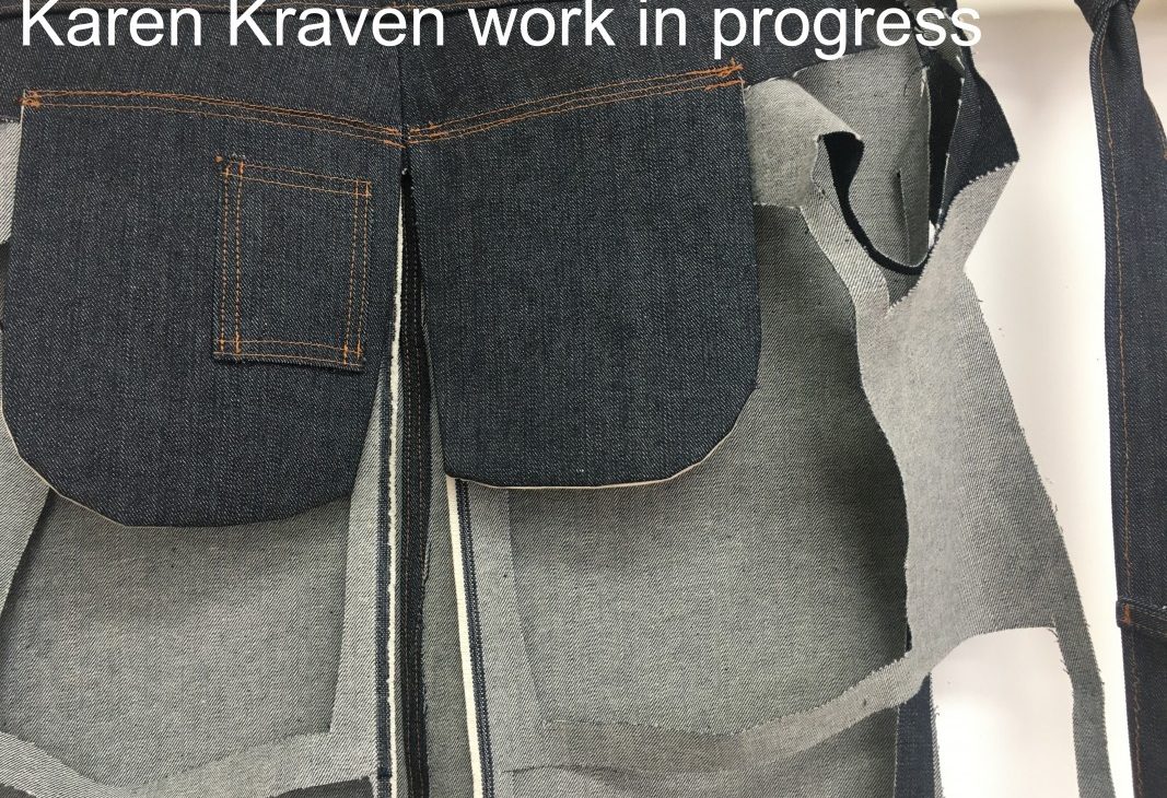 Detail shot of artist Karen Kraven's work in progress; Blue denim fabric with contrasting stitch elements and pattern cut outs visible