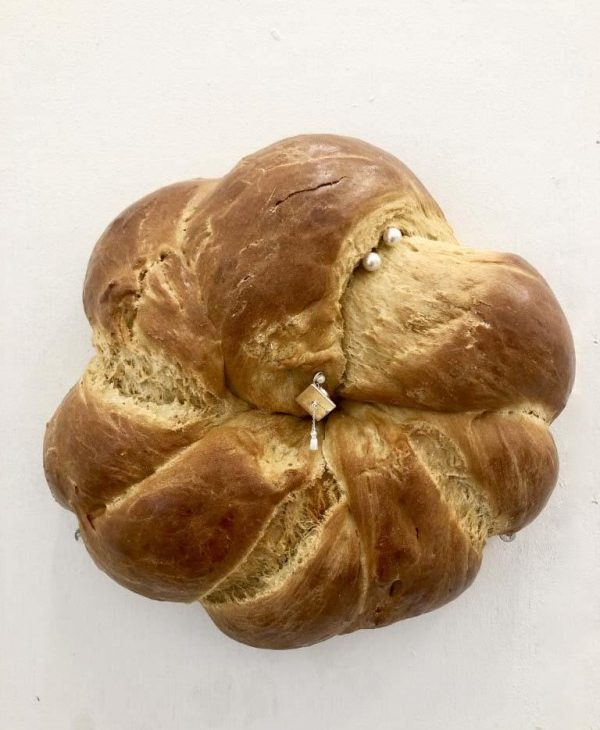 Bread bun with interlocking folds, akin to braiding, two pearls on the uppermost fold with a sterling silver square and pearls at the centre of the bun