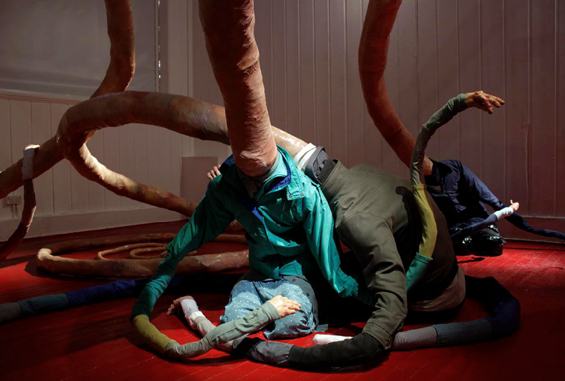 Floor based sculpture with tendril shaped limbs and clothing.