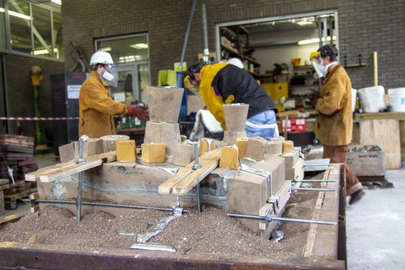 A team in protective clothing working on an aluminum pour, view of the moulds.