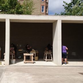 Bays of the Courtyard with people working at wooden tables on wood carving.