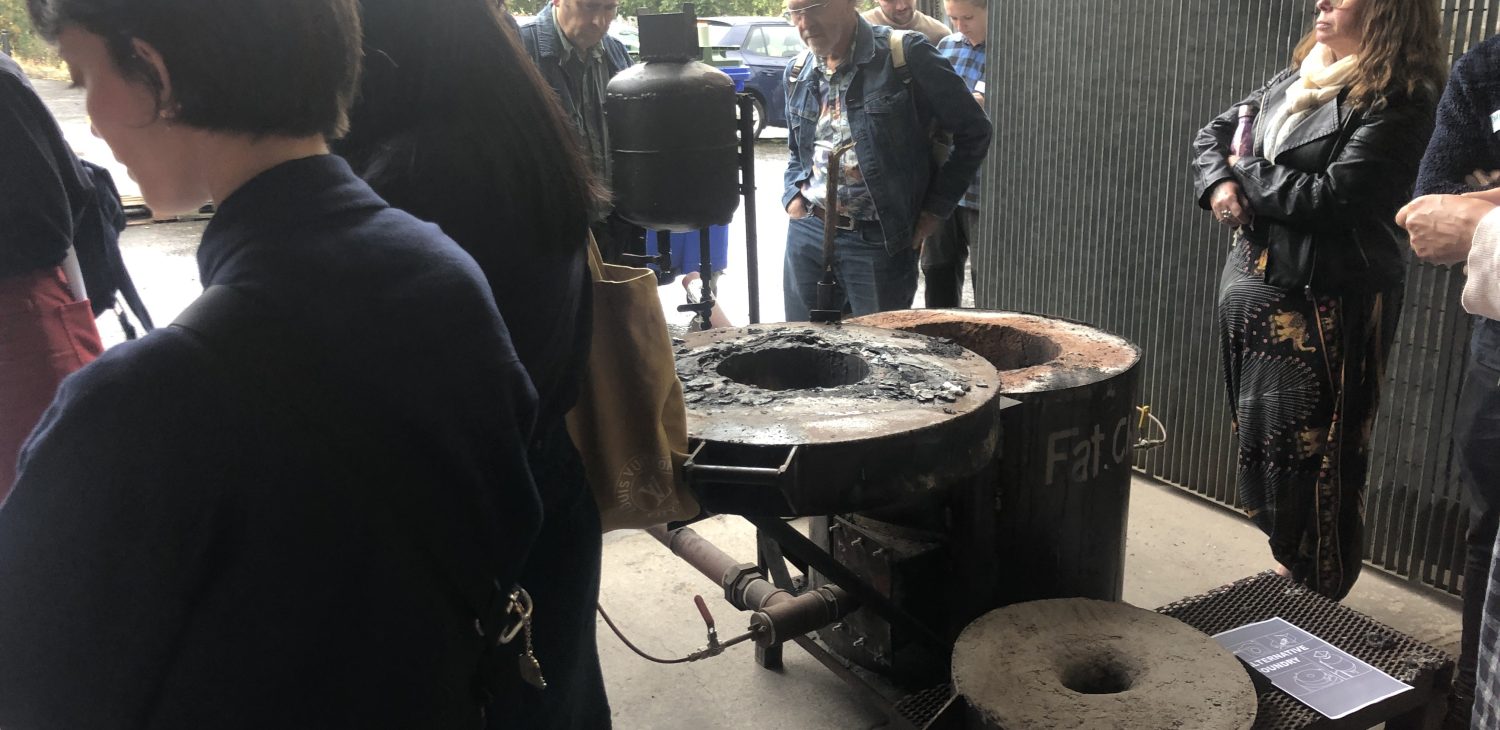 Audience members looking at the oil-fueled furnaces during an introductory tour, Alternative Foundry Practices.
