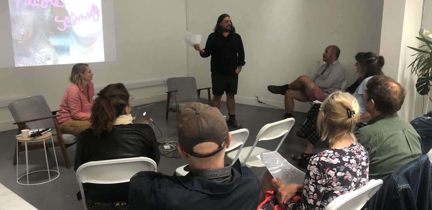 Necole Schmitz illustrated talk being introduced by Stephen Murray, on front of a seated audience, Alternative Foundry Practices events.