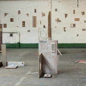 Image of David Lemm's work in wood and paper installed on the floor of an industrial building.